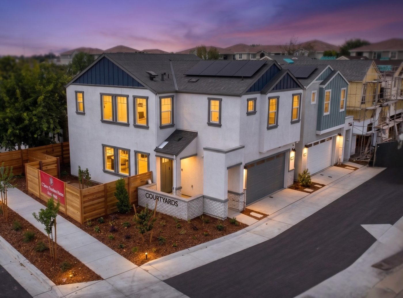 Courtyards at Cotton Lane — Aerial view of model homes and Courtyards entry monument at dusk